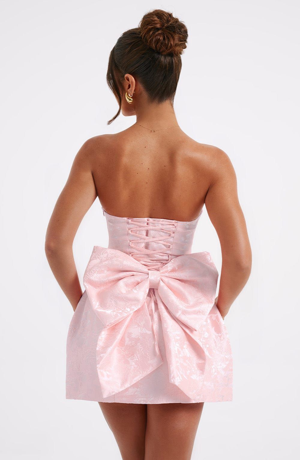 Blush elenora mini dress back view with oversized bow detail and lace-up corset design
