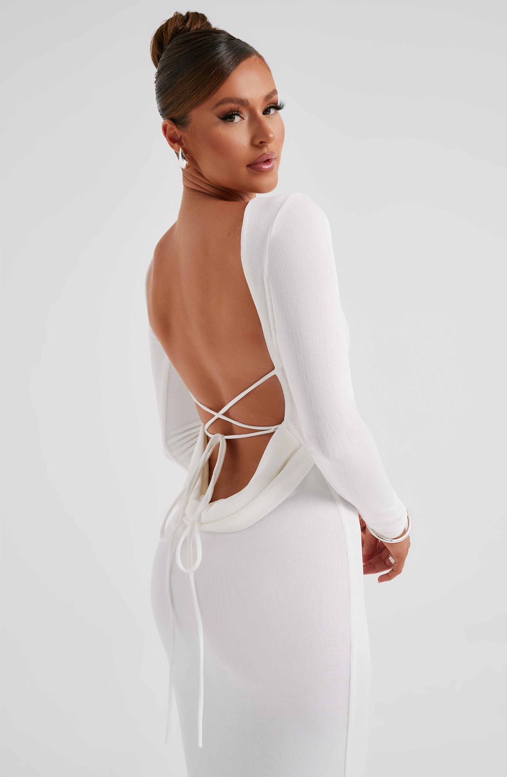 Side view of white Anastassia maxi dress with figure-hugging fit and long sleeves