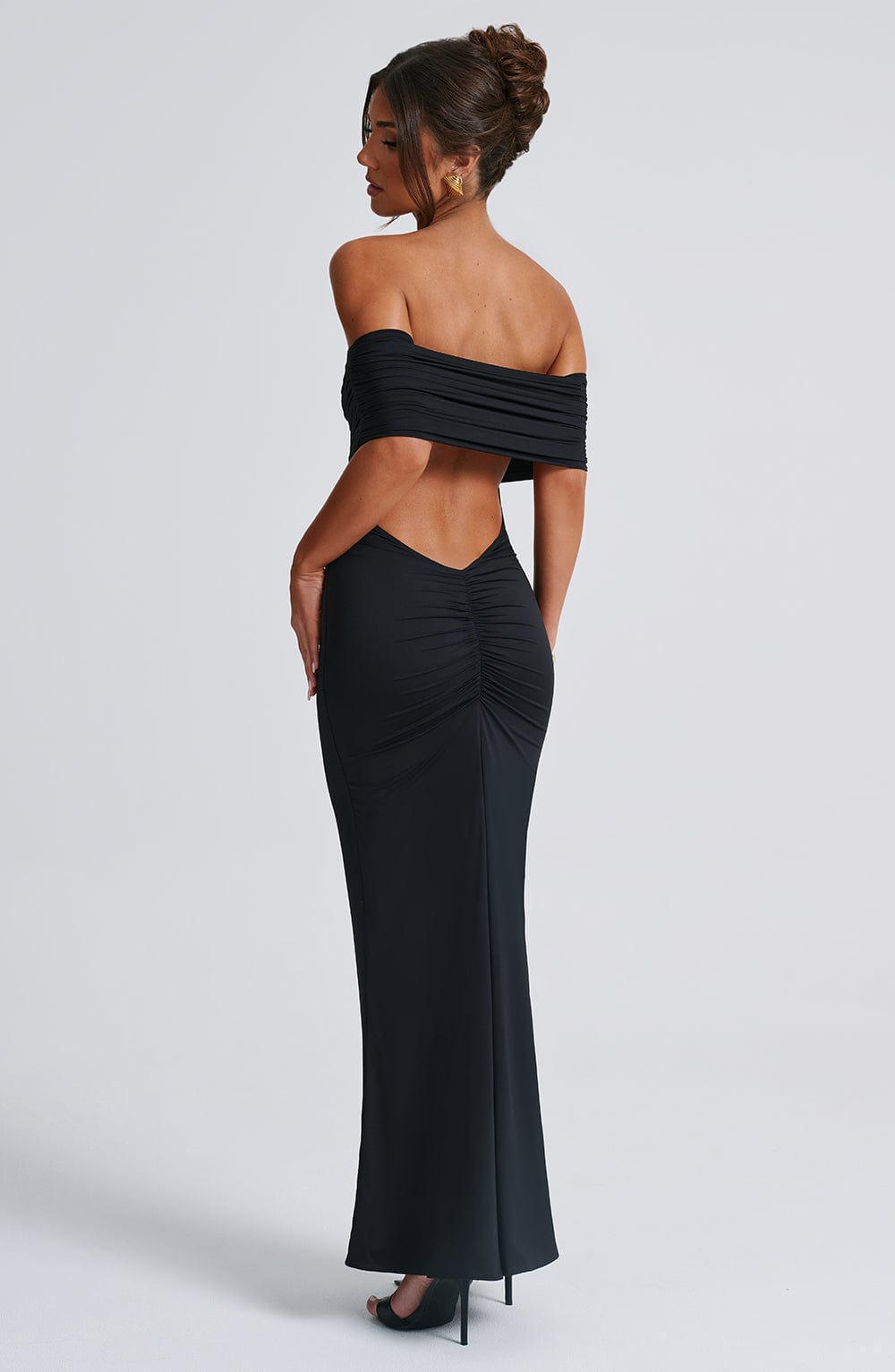 Black off-shoulder gown with open back on a white background