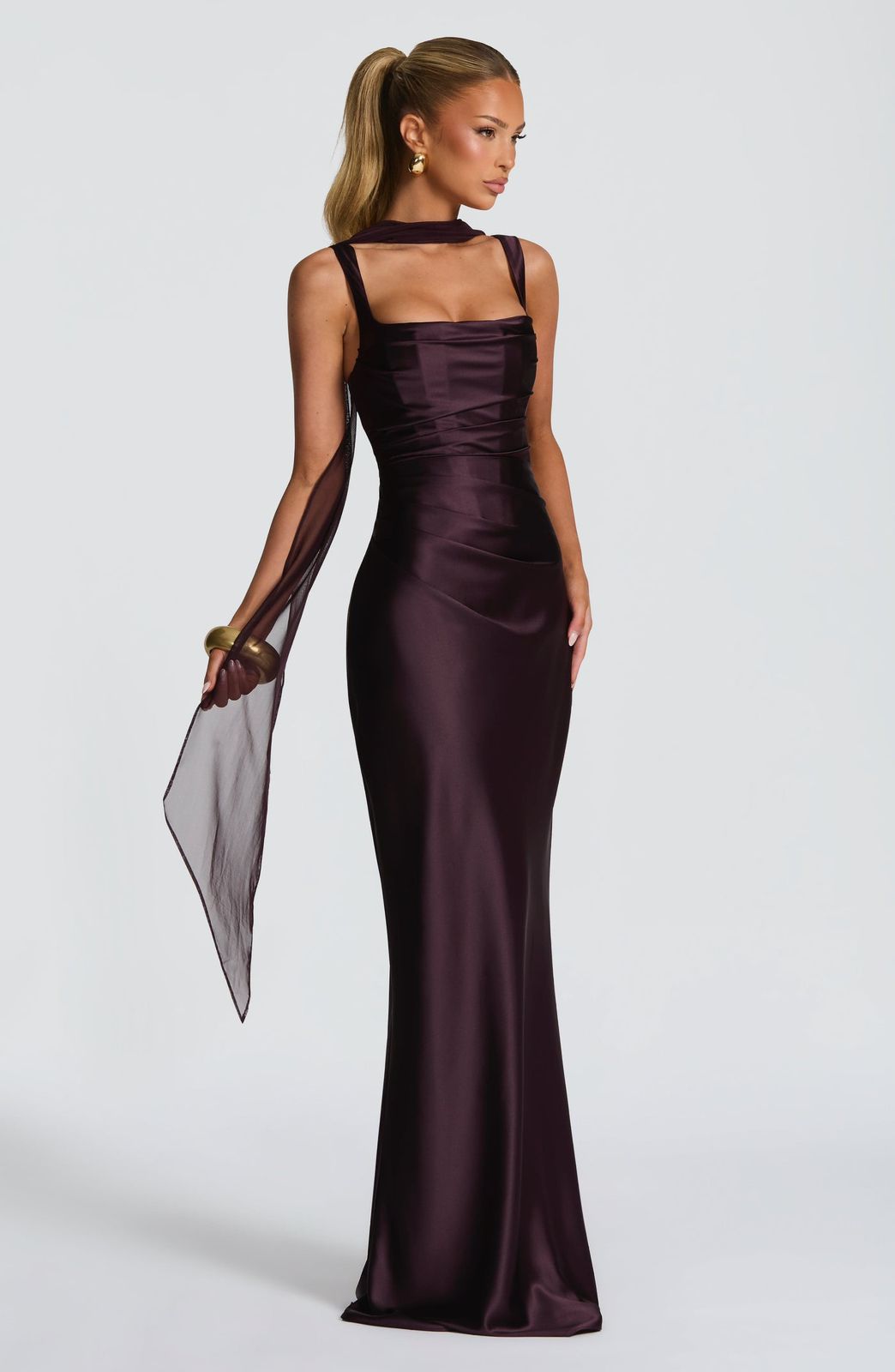Side profile of the Calanthe Maxi Dress highlighting the asymmetric pleats on the bodice and the flowing maxi dress