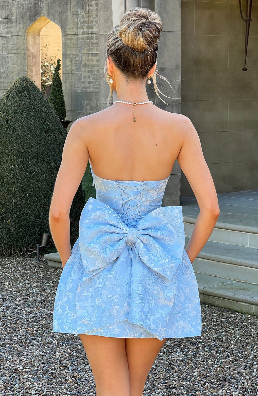 Elenora mini dress back view with oversized bow detail and lace-up corset design