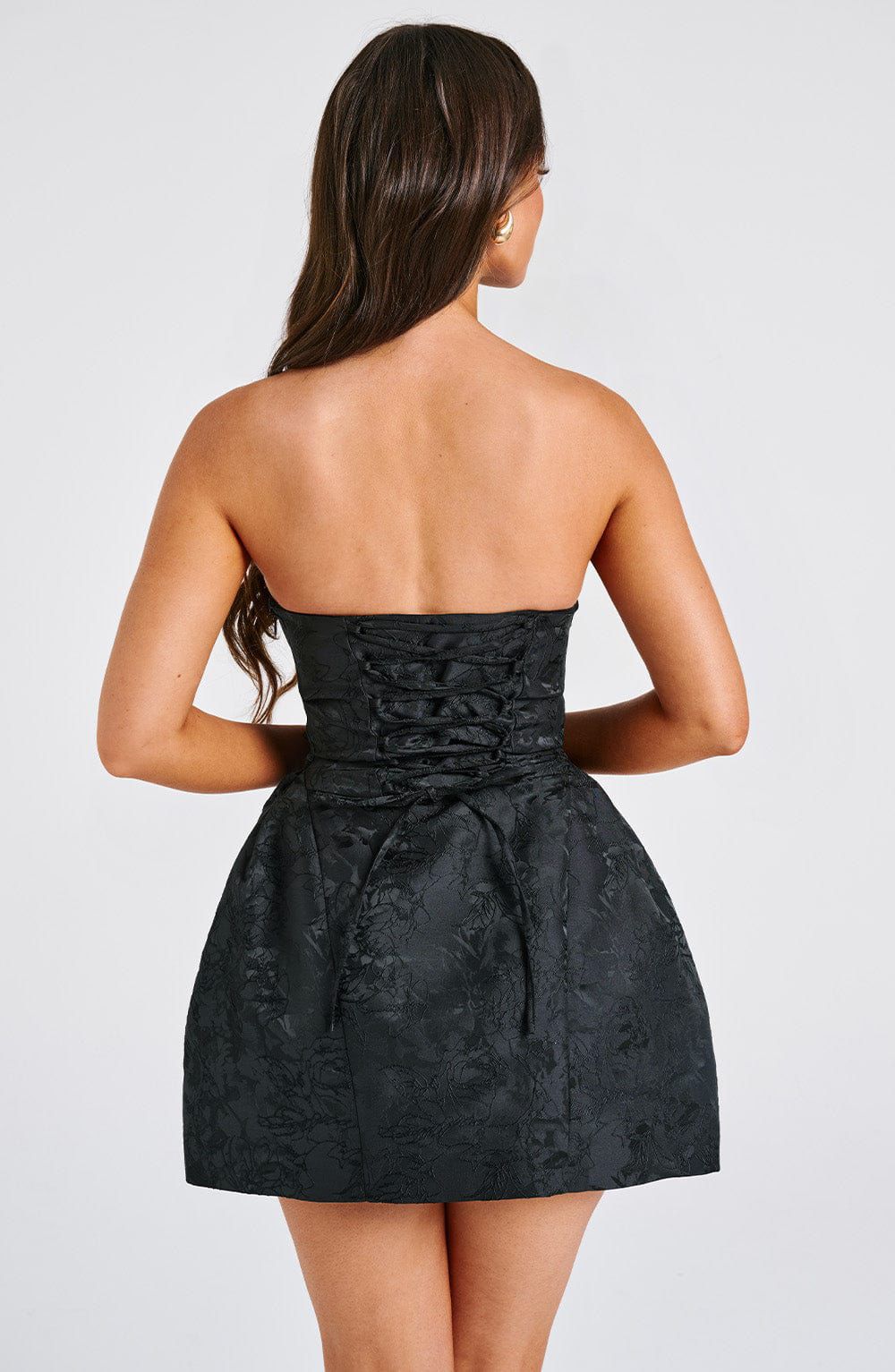 Back view of the Elenora Mini Dress showing the oversized detachable bow and lace-up corset detail