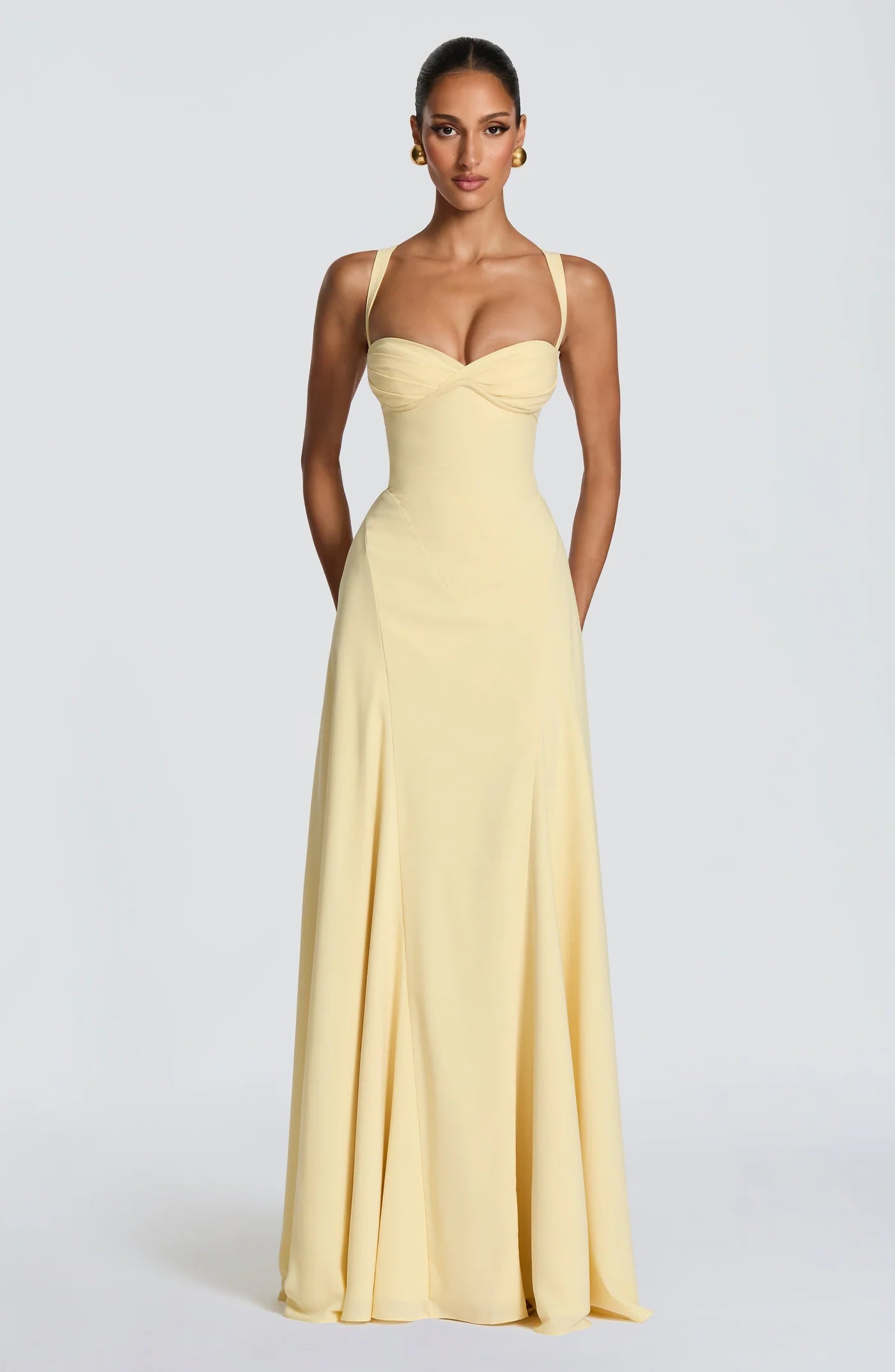 Woman wearing a light yellow evening gown on a white background