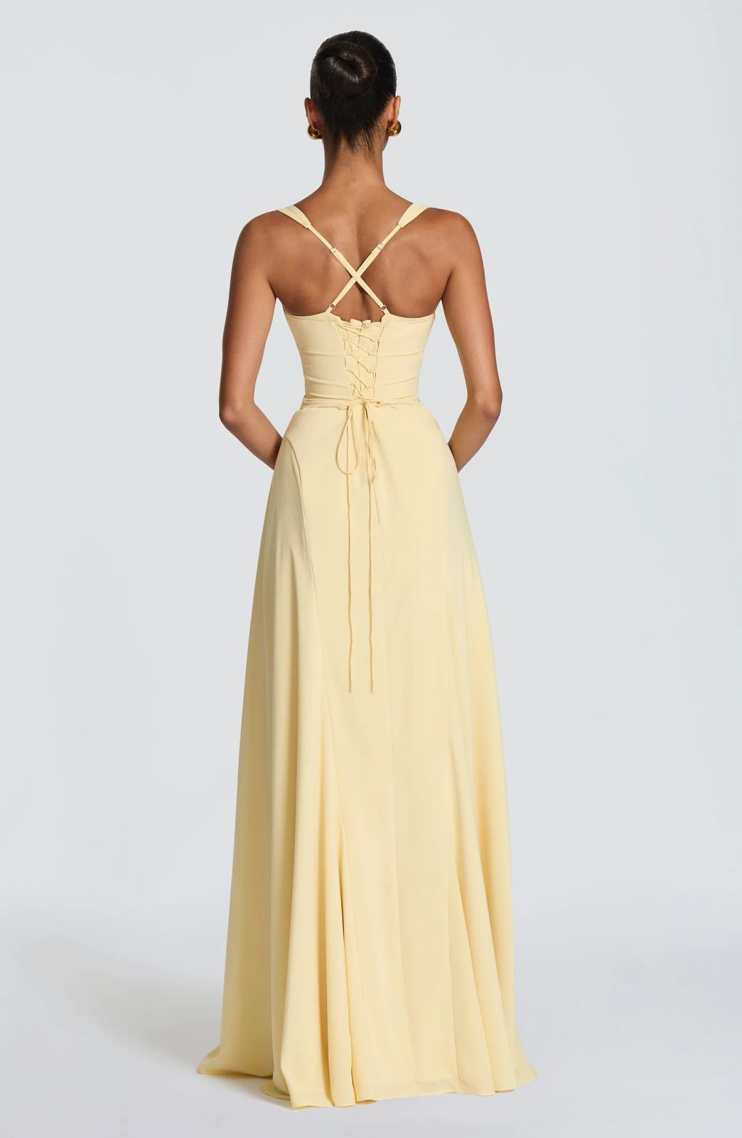 Back view of the Sura Maxi Dress showing the elegant lace-up details, open back, and cinched waistline fit.