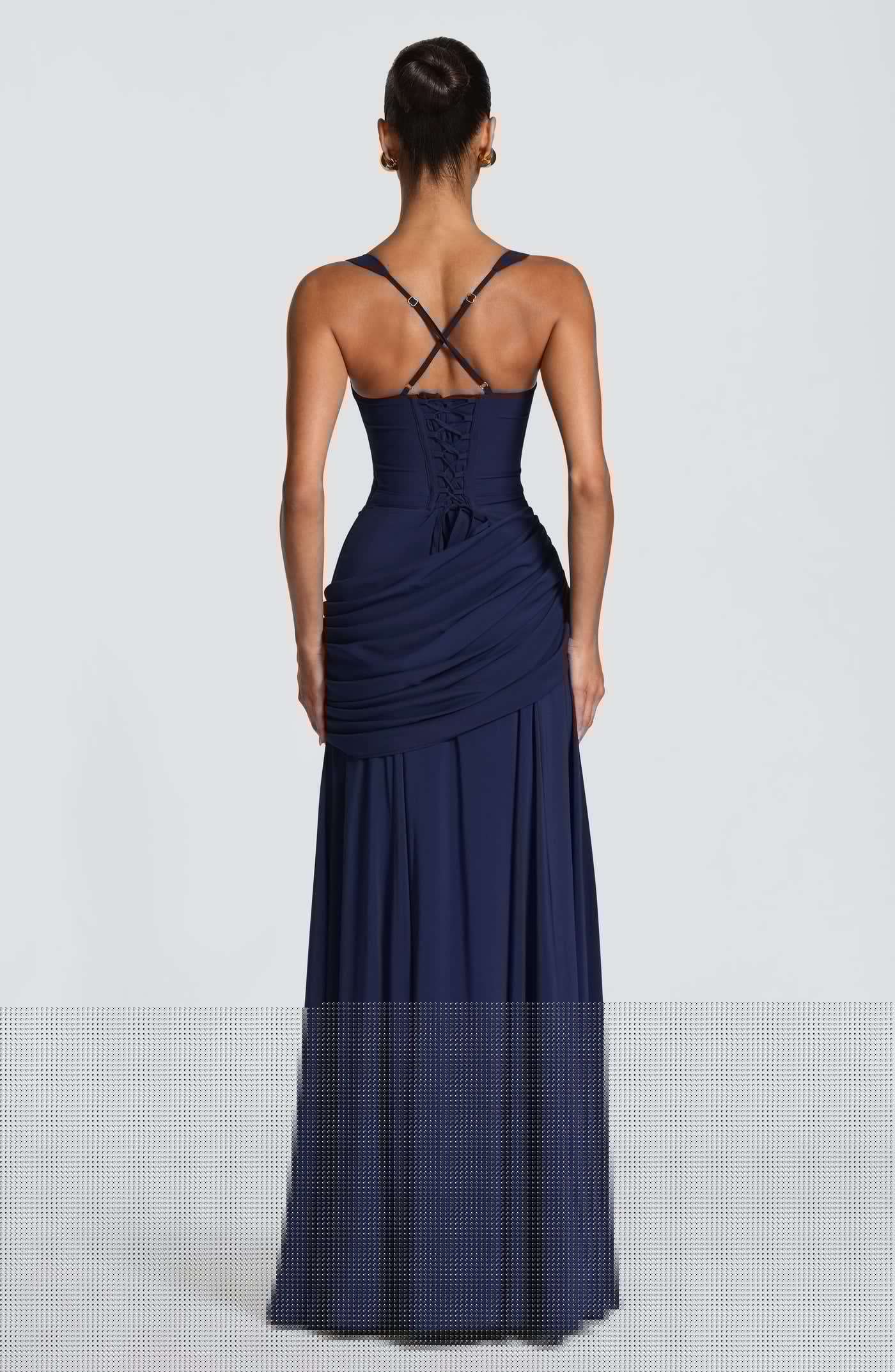 Back view of the Sura Maxi Dress showing the elegant lace-up details, open back, and cinched waistline fit.